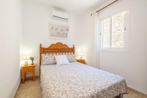 a white bedroom with a bed and a window at Can Freixa - Sóller in Sóller