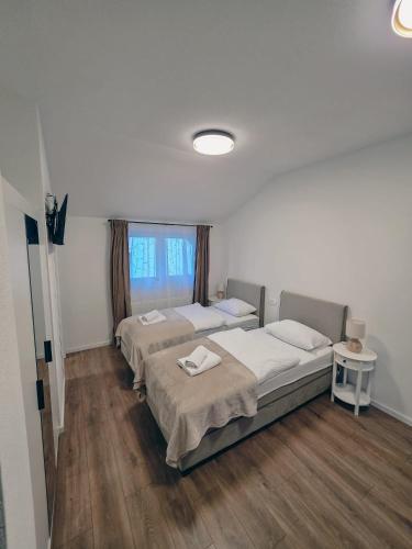 a room with three beds and a window at Guesthouse Gacka idila in Otočac