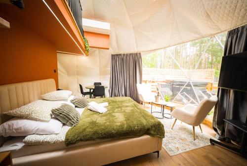 ein Schlafzimmer mit einem Bett und einem großen Fenster in der Unterkunft Skyview Glamping Jacuzzi , Sauna in Ludwinów