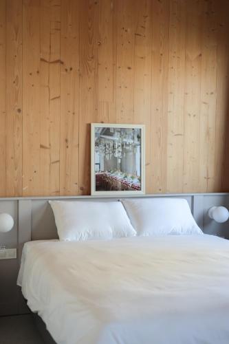 a bedroom with a white bed with wooden walls at Casa Brutarului in Timişoara