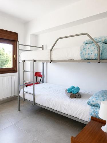 a bedroom with two bunk beds and a chair at Villa Montserrat in Bagá