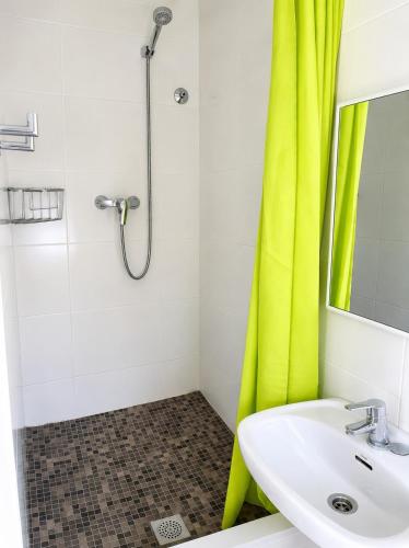 a bathroom with a sink and a shower with a yellow curtain at Villa Montserrat in Bagá