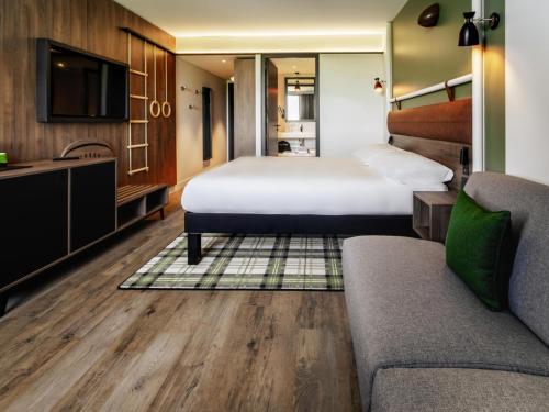 a hotel room with a bed and a couch at ibis Styles Castelnaudary in Castelnaudary