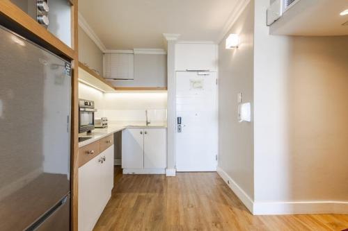 a kitchen with white cabinets and wooden floors at Breakers Resort 316 Umhlanga in Durban