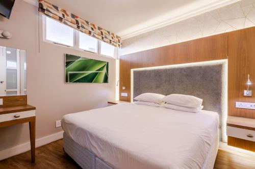 a bedroom with a large white bed and two windows at Breakers Resort 316 Umhlanga in Durban