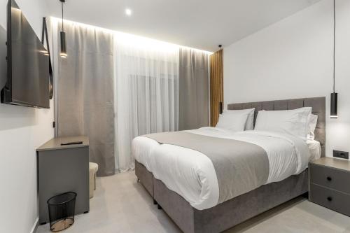 a bedroom with a large bed and a television at Elia village in Kalithies
