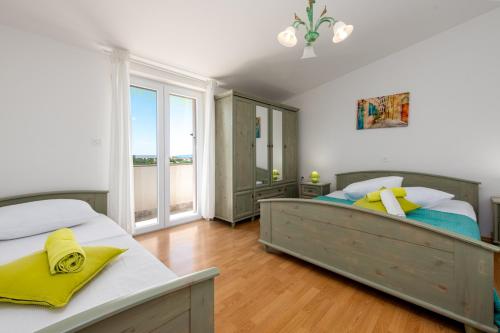 a bedroom with two beds and a large window at Villa Ivana holiday home in Mrljane