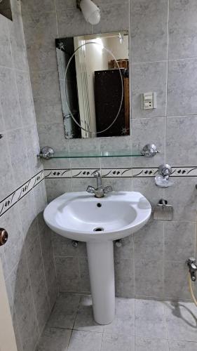 a bathroom with a white sink and a mirror at ButtLodges - 1 in Islamabad