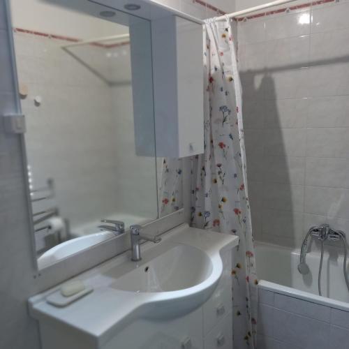 a bathroom with a sink and a mirror and a tub at Casa Blu in Piediluco