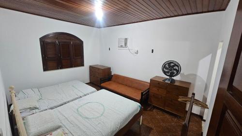 a bedroom with a bed and a dresser and a window at Casa em Salinas in Salinópolis