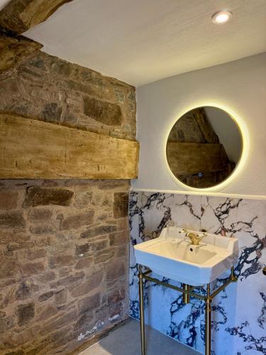 ein Badezimmer mit Waschbecken und einer Ziegelwand in der Unterkunft Three Cocks Hotel in Brecon