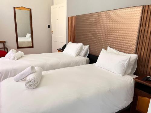 two beds in a hotel room with towels on them at Galenia Boutique Hotel in Springbok