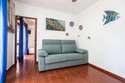 a living room with a green couch in a room at Apartamento Vargas in Monte Gordo
