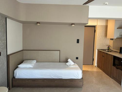 a bedroom with a bed with white sheets at 7 Suites in Skiathos