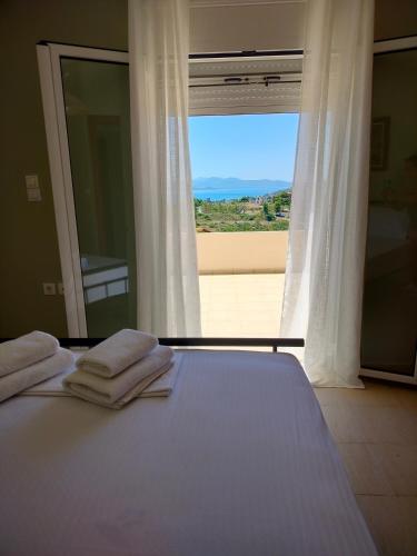 a bedroom with a bed with a view of the ocean at Serenity Horizon Villa in Theologos