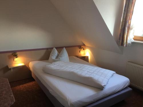 a bedroom with a white bed with two lamps at Hotel & Restaurant Park Cafe ISA in Erfurt