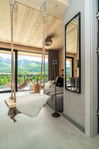 a room with a swinging bed and a mirror at Apartamenty Premium VIEW JACUZZI & SAUNA in Kościelisko