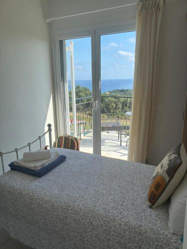 a bedroom with a bed and a view of a balcony at Captains View in Kefallonia