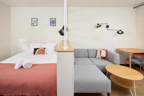 a bedroom with a bed and a couch at Hife Toulouse Sud Labège in Labège