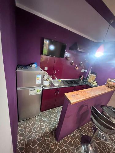 a purple kitchen with a sink and a refrigerator at Green Paradise in Qax