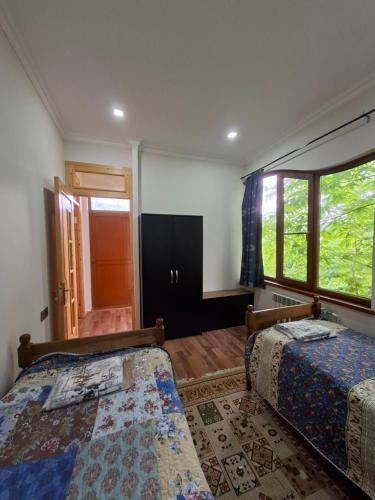 a bedroom with two beds and a window at Green Paradise in Qax