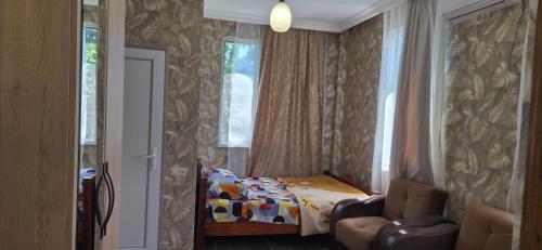 a bedroom with a bed and a window and a chair at Green paradise in Batumi