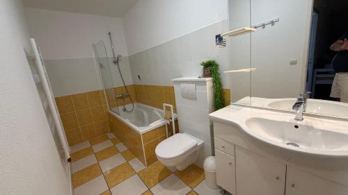 a bathroom with a sink and a toilet and a tub at La maison de Virginie 6 a 12 personnes -300 m de la plage- vélos a disposition in Saint-Cyprien-Plage