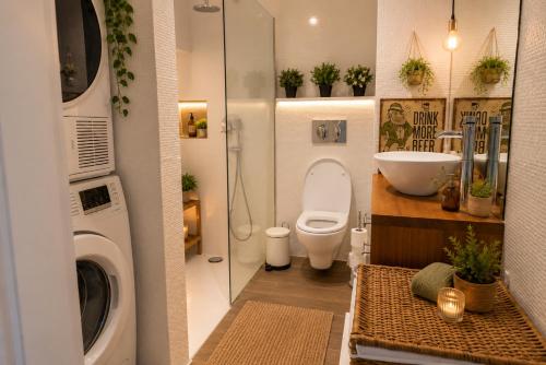 a bathroom with a toilet and a sink and a washing machine at Jack&Lily's in Évora