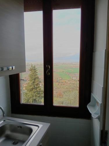 a window in a bathroom with a view of a field at La Terrazza sul Lago in Panicale