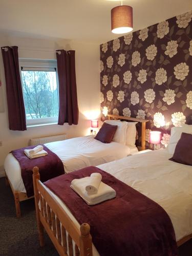 a hotel room with two beds and a window at Bathgate Contractor and Business Apartment in Bathgate