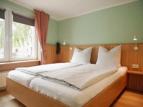 a large bed in a bedroom with a large window at Hafen Bungalow in Kirchdorf