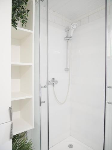 a shower with a glass door in a bathroom at Hafen Bungalow in Kirchdorf
