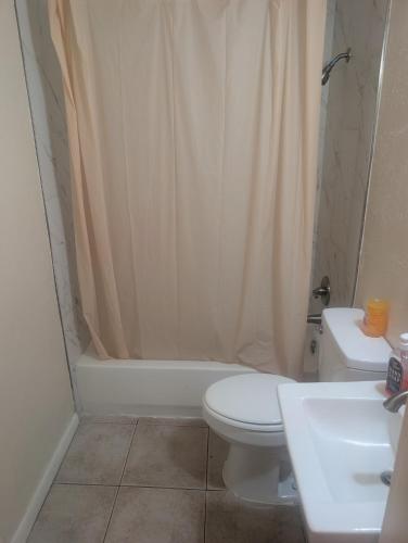 a bathroom with a toilet and a shower curtain at Bungalow Bleu in St. Petersburg