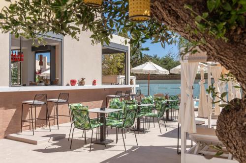 a patio with tables and chairs next to a pool at Meramaglia Hotel in Malia