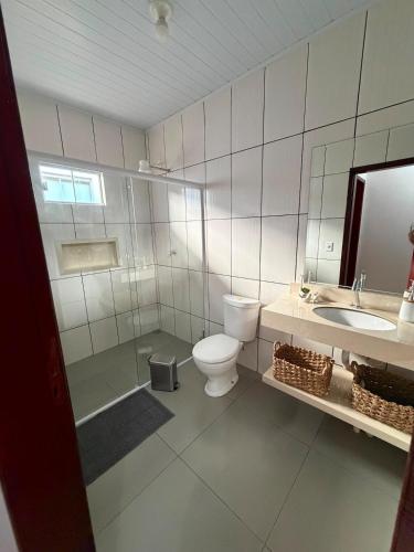 a bathroom with a toilet and a sink at Casa completa 3 quartos in Sinop