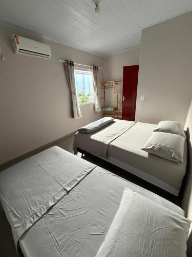 a bedroom with two beds and a window at Casa completa 3 quartos in Sinop