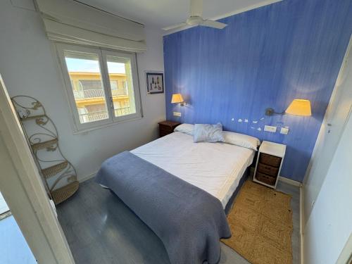 a blue bedroom with a bed and a window at Mare Nostrum 143 in Torroella de Montgrí