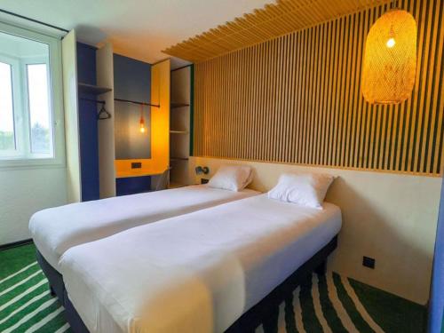 two beds sitting next to each other in a room at ibis Styles Paris Hippodrome de Vincennes in Joinville-le-Pont