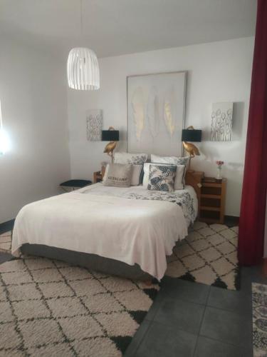 a bedroom with a large bed and a chandelier at Maison La Suite 27 in Guingamp