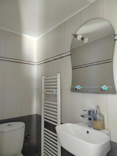 a bathroom with a white sink and a mirror at Serenity Horizon Villa in Theologos