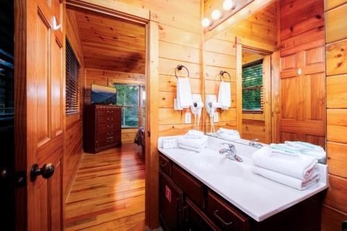 a bathroom with a sink in a wooden cabin at Evening Star in Gatlinburg