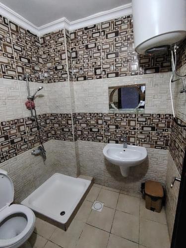 ein Badezimmer mit Toilette und Waschbecken in der Unterkunft شقة ريماس in Irbid