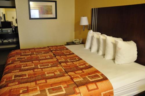 a hotel room with a large bed with white pillows at Motel 6-Little Rock, AR - Airport in Little Rock
