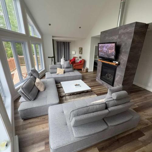 a large living room with couches and a fireplace at Pool Table Private Beach - Breakfast Included - Fontainebleau in Labelle