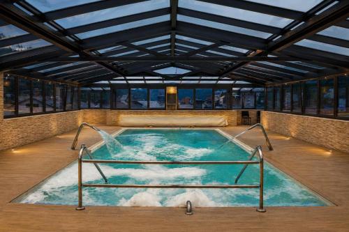 a hot tub in a building with a water fountain at Hotel Best Andorra Center in Andorra la Vella