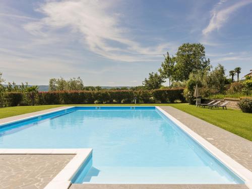 a large swimming pool in a yard with a lawn at Apartment Rosa Alba by Interhome in Bolsena