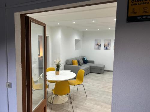 a living room with a table and yellow chairs at Cal Botey in Ripoll