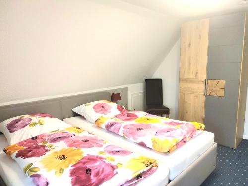 two beds in a room with flowers on them at Sommerwind in Eutin