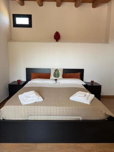 a bedroom with a large bed with two towels on it at Tenute Cinquanta in Menfi