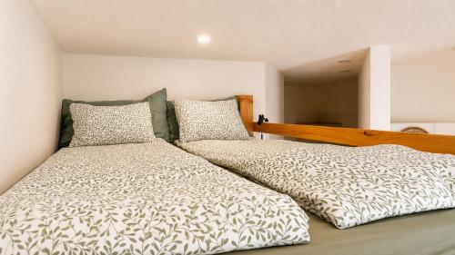 two beds sitting next to each other in a bedroom at Petit Canada - Studio à louer in Champex